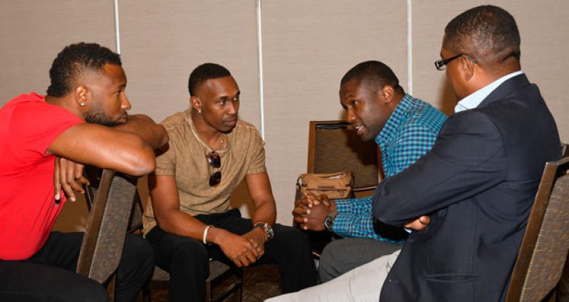 L-R: West Indies players Kieron Pollard and Dwayne Bravo sit with WIPA president Wavell Hinds and WICB president Dave Cameron.