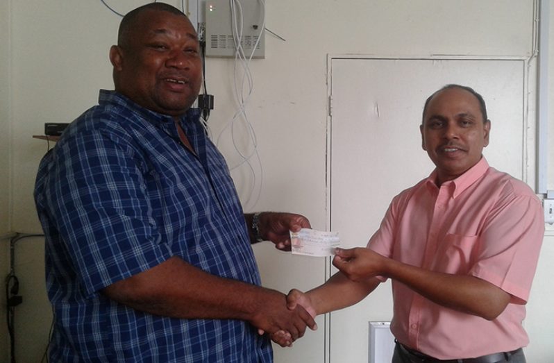 BCB president Hilbert Foster receives the sponsorship cheque from Chandradat Chintamani.