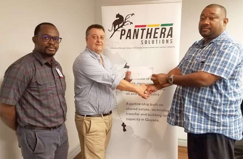 Panthera Solution’s General Manager Andrew Dinsdale hands over donation to RHTY&SC Secretary/CEO Hilbert Foster in the presence of Project Manager, Ray McLean.