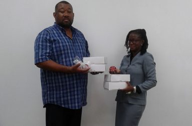 Bornique Jordan Meredith of Ming’s hands over the cricket balls to RHTYSC CEO, Hilbert Foster