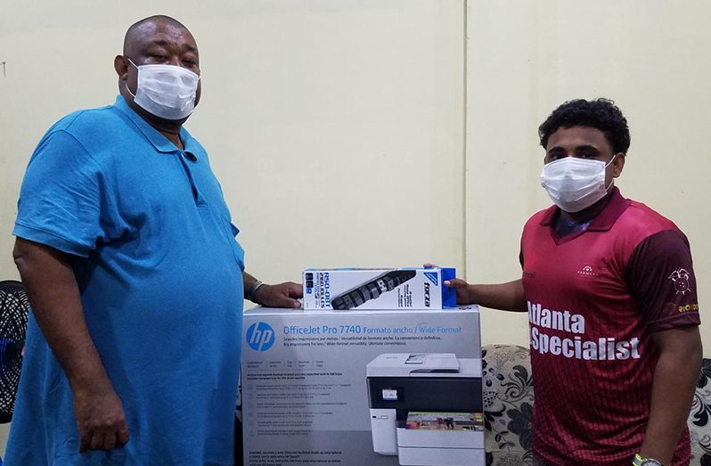 BCB president, Hilbert Foster and PRO, Simon Naidu, pose with the photocopier.