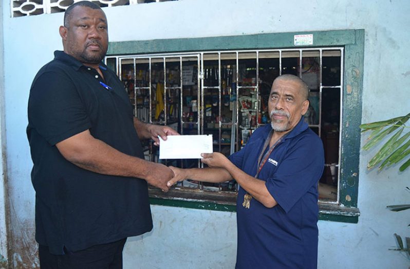BCB president Hilbert Foster receives the sponsorship from Flavio Da Silva.