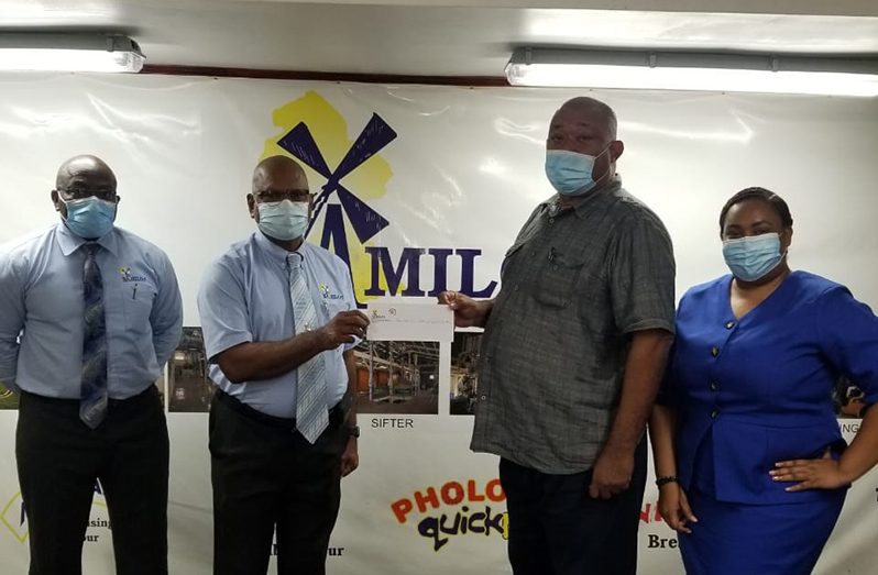 RHTYSC Hilbert Foster receives sponsorship from NAMILCO Managing Director Bert Sukhai in the presence of company officials Fitzroy McLeod and Alicia Anderson.