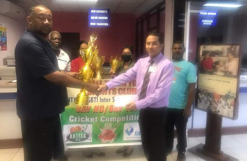 Andre Yhap of the GBTI Port Mourant Branch hands over sponsorship to RHTYSC Secretary Hilbert Foster in the presence of RHTYSC AND GBTI officials