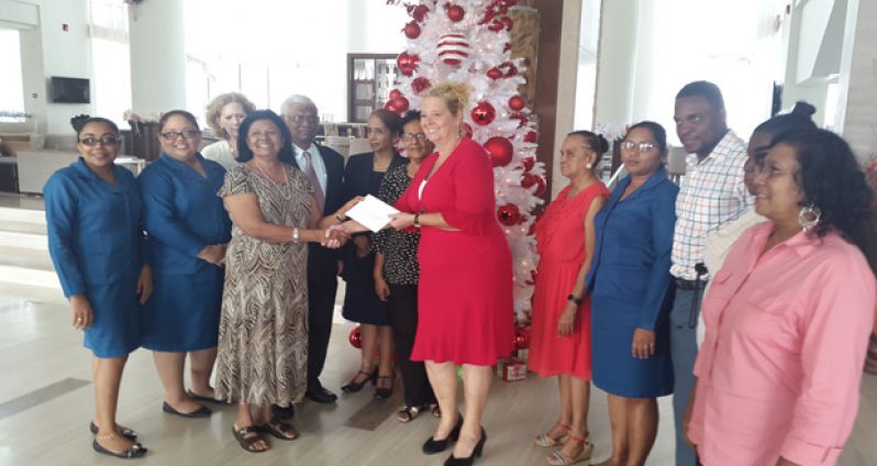 Gafoor Foundation Administrator Ameena Gafoor hands over a cheque to Ruimveldt Children Aid Centre Jessica Hatfield in the presence of her husband Sattaur Gafoor, staff and beneficiaries