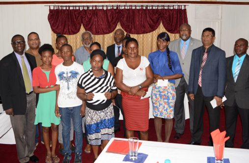 Some of the recipients of the Guyana Police Force Fallen Heroes Foundation Inc flanked by the members of the foundation.