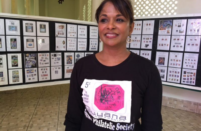 Ann Wood wearing a tee shirt with an image of the British Guiana Magenta Stamp