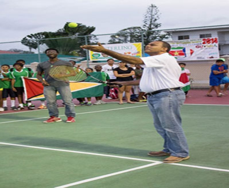 Minister of Sport, Dr Frank Anthony offers the Ceremonial Serve to signal the start of the Inter-Guiana Games Tennis Tournament.