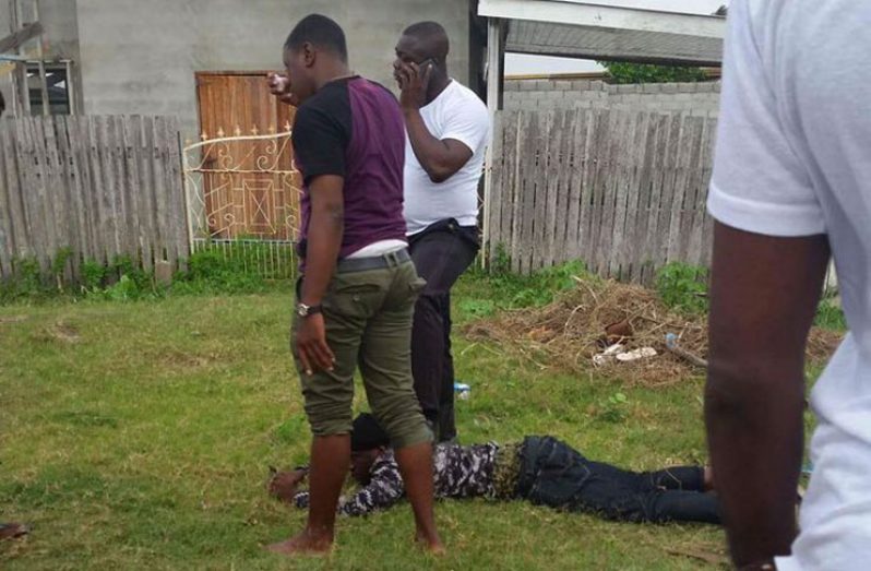 Cordel Fraser (on the ground) was arrested after police observed him acting in a suspicious manner