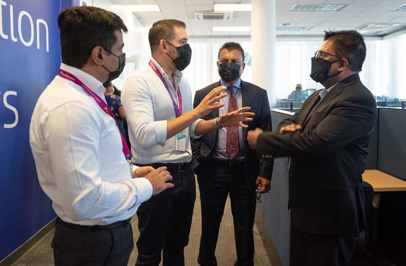 Senior Minister in the Office of the President with responsibility for Finance, Dr. Ashni Singh, and CEO of Go-Invest, Dr. Peter Ramsaroop, engage officials of Teleperformance during a tour of the company’s Camp Street facility, on Monday