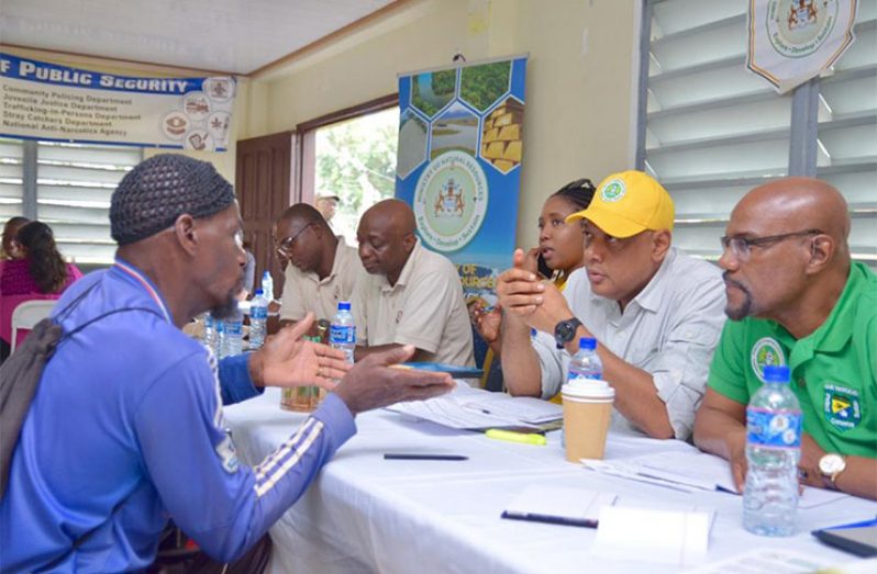 Natural Resources Minister, Raphael Trotman,
listening to the concerns of one of
the miners of Mahdia, Region Eight, who
participated in Government’s Outreach on
Friday. Minister Trotman formed part of a
team of ministers, government officials,
and public servants who journeyed to the
district to provide much-needed services
and hear the concerns of residents. (DPI Photo)