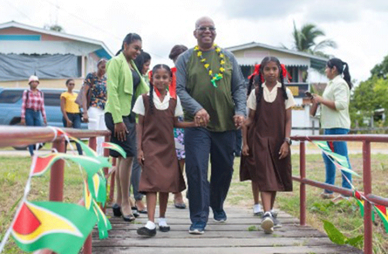 With a staggering $52B already invested in the education
sector for this year, Finance Minister Winston Jordan said
significant funds will be pumped into the education sector
come 2020. In this photo he is being escorted by two Success
Primary School pupils during his visit to Leguan. (DPI Photo)