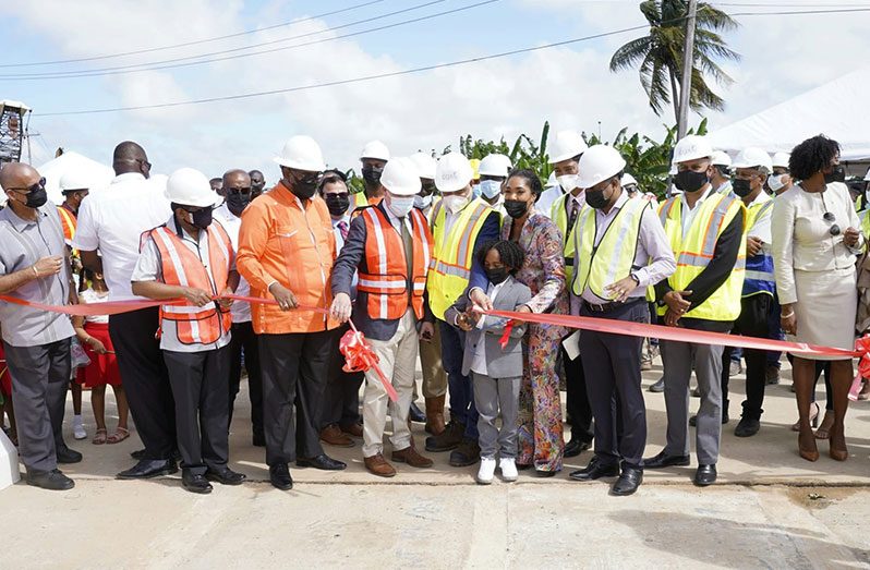President Dr Irfaan Ali, government officials and representatives of CGX assist the process in the cutting of the ceremonial ribbon to commission the bridge