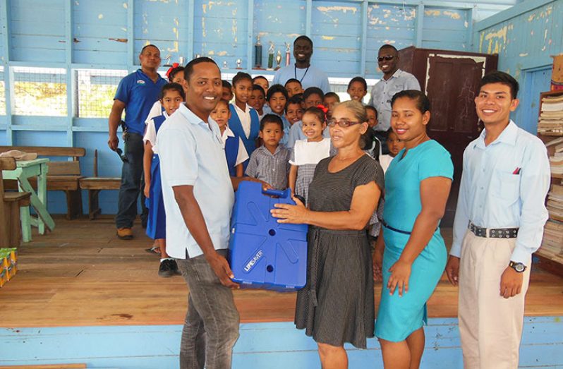 GWI’s Officer in Charge of Region 7, Mr. Elson Khirattie, presents a Lifesaver water filter to Headmistress
of Karrau Creek Primary School, Ms. Theresa Braithwaite, who is flanked by two teachers