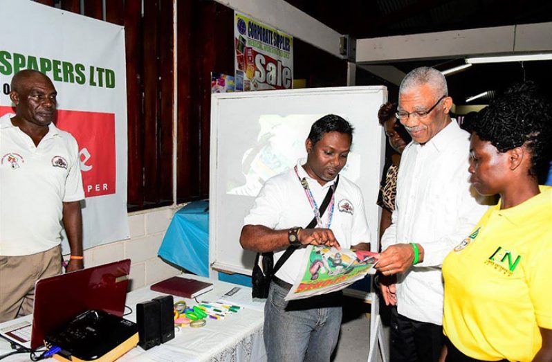 Marketing coordinator of The Guyana Chronicle, Akash Persaud, presenting a copy of this newspaper’s special 50th Independence Anniversary Sports
supplement to President David Granger at the Linden Trade and Investment Fair at the Egbert Benjamin Exhibition and Conference Centre, Linden. (Ministry of
the Presidency photo)