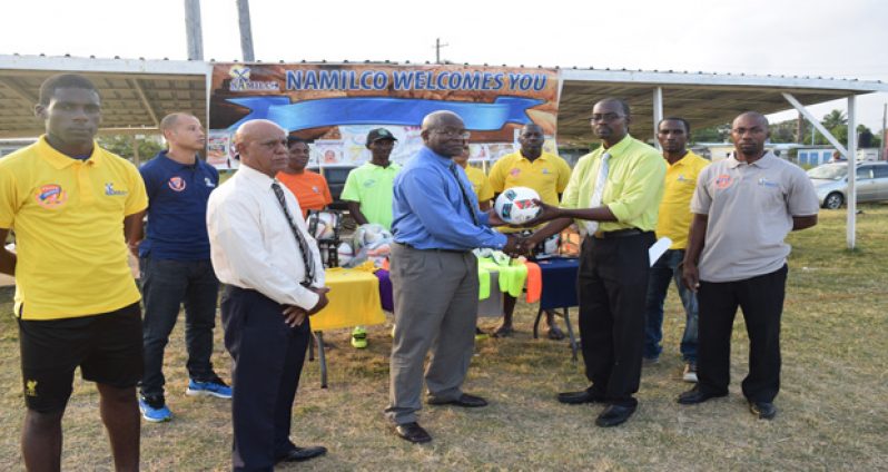 In this Cullen Bess-Nelson photo, NAMILCO’S Finance Controller Fitzroy McLeod (left) hands over one of the footballs to Fruta Conquerors Club secretary Daniel Thomas, while Public Relations Consultant of the company Hafeez Khan (extreme left) and other club executives look on.