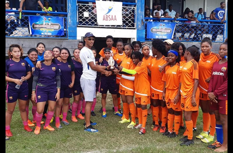 Fruta Conquerors Ladies collect their trophy. Also in picture (left) are members of the Lady Panthers team.