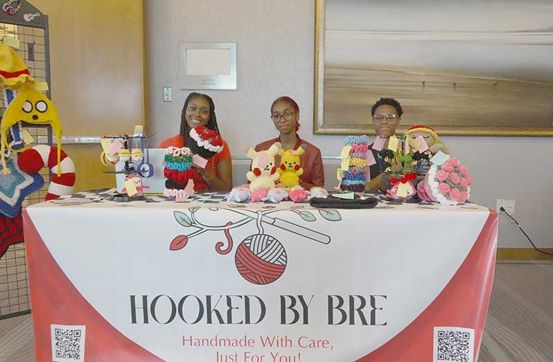 Brianna Exeter, founder of Hooked by Bri, (centre) showcasing her handmade crochet items