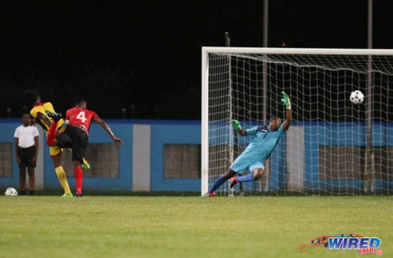Guyana’s Sheldon Holder (left) heads past Trinidad’s goalkeeper Marvin Phillip (right) and defender Sheldon Bateau for the opening goal during international friendly action at the Ato Boldon Stadium in Couva. (Photo compliments: Chevaughn Christopher/Wired868)