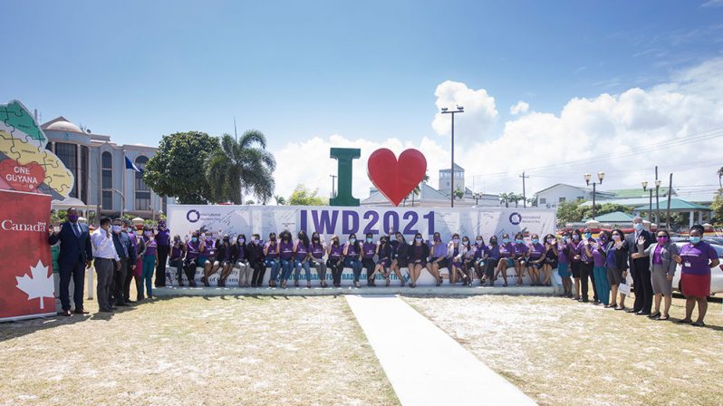 Staff of the GBTI and other officials at the ‘I Love Guyana’ sign to mark International Women’s Day