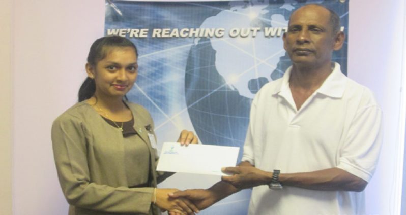 The Rose Hall Town Youth and Sports Club (RHTY&SC) assistant organising secretary, Ravin Kissionlall, receives the sponsorship cheque from Ms Ramdeo.