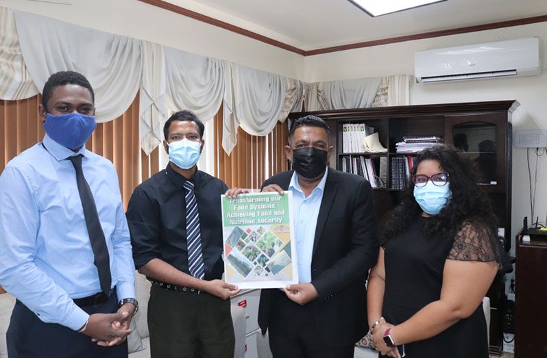 Minister of Agriculture, Zulfikar Mustapha (centre right) receives a copy of the Agriculture Month 2021 supplement from Editor-in-Chief, Tajeram Mohabir (centre left); flanked by Online Editor, Derwayne Wills (left); and Chief Reporter, Rehana Ahamad (right)