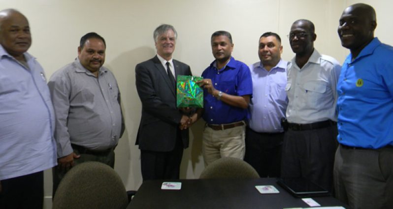 GCB Secretary Anand Sanasie handing over a token of appreciation to Australia’s High Commissioner to Guyana, John Pilbean.