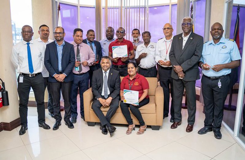 Minister within the ministry of Public works, Deodat Indar (seated at left) with the employees who were recognised on Friday along with other GCAA staff (DPI photo)