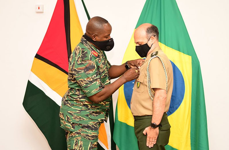 Chief-of-Staff of the GDF, Brigadier Godfrey Bess, confers the Military Efficiency Medal (MEM) on outgoing Brazilian Military Attaché in the Embassy of the Federal Republic of Brazil, Colonel Marcelo Ambrosio (Photo courtesy of GDF)
