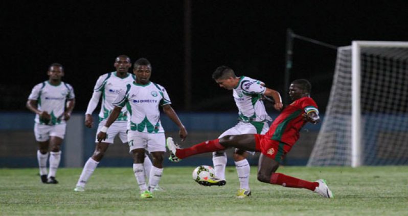 GDF captain Selwyn Isaacs attempts a tackle on W-Connection’s Jhon Lopez during their CFU Championship showdown in Trinidad last Wednesday.