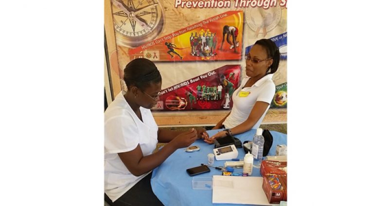 GDF Sergeant Geralda Jeffery as she attends to a visitor at the recent medical outreach partnered by UG students and the GDF