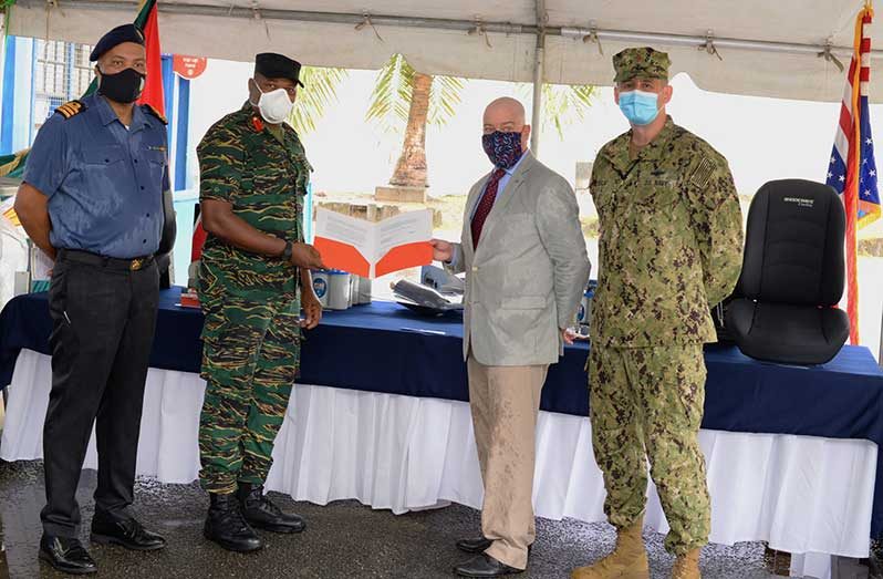 GDF Inspector-General, Colonel Trevor Bowman, receives the signed document from US Charge d'Affaires, Mark Cullinane, for $40M in boat supplies at the simple handover ceremony