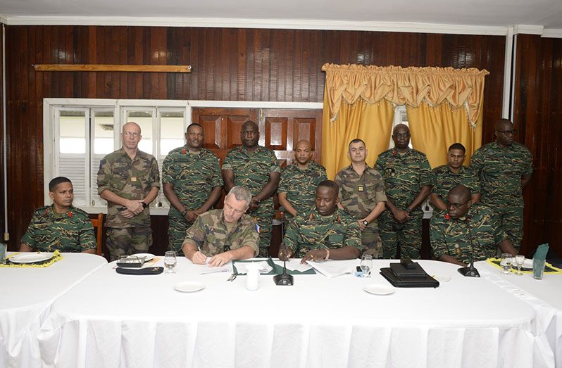 Chief-of-Staff, Brigadier Godfrey Bess and Major-General Xavier Buisson sign the new understandings and agreements to strengthen military cooperation and collaboration, at the Officers’ Mess, Base Camp, Ayanganna (GDF photo)