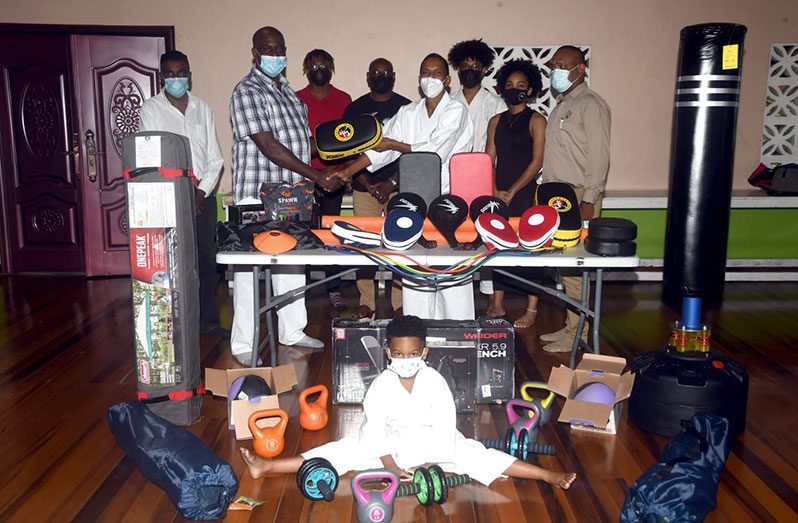 Sensei Aubrey Mendonca (second from left) hands over the gear to Chairman Sensei Jeffrey Wong in the presence of other executive members and students