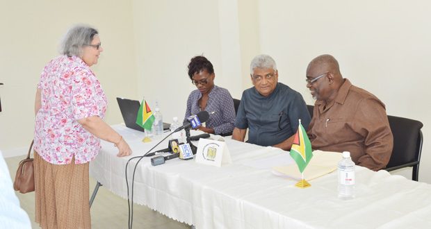 GECOM Commissioner Bibi Shadick engages Chief Elections Officer Keith Lowenfield (right) and Dr Steve Surujbally before the start of Saturday’s press conference. At left is GECOM’s PRO, Tamara Rodney