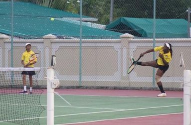 Afruica Gentle makes a powerful return in U-14 play while Shivanie Persaud looks on
