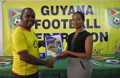 GFF's Social Media Officer, Keeran Williams, receives partnership agreement from Maad 97.5FM Human Resources Manager, Nicole Griffith.
