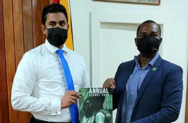 GFF president Wayne Forde (right) presents the 2020 GFF Annual Report to Minister of Culture, Youth and Sport, Charles Ramson Jr.