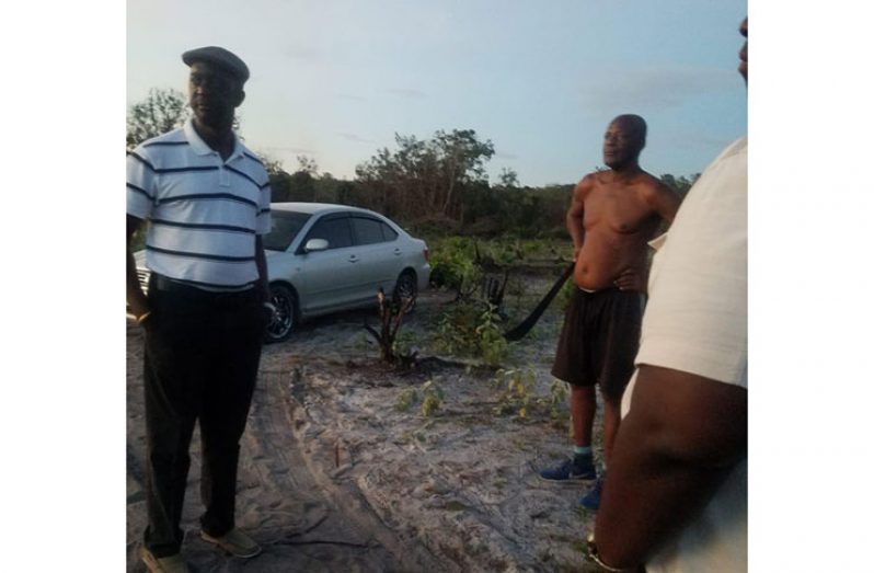 GLSC CEO, Trevor Benn speaking with the illegal developer of the lands (without shirt) and other residents