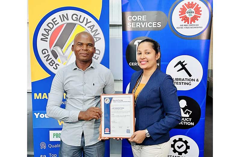 Mr. John Luke receives his certificate from GNBS Technical Officer Rosmarie Liliah