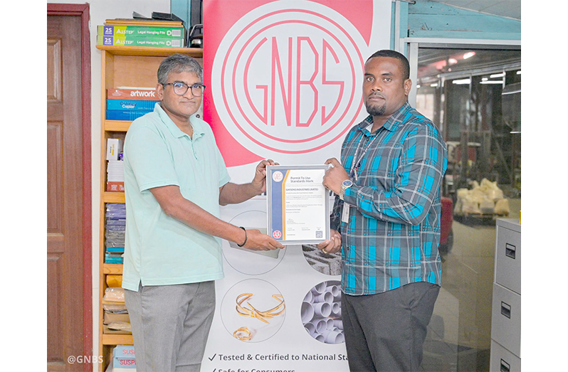 GNBS Head of Certification Services (ag) Keon Rankin, handing over the certificate to Deputy Factory Manager at Gafsons Industries Jitendra Mishrah