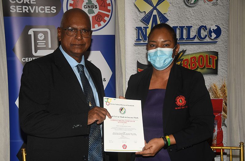 NAMILCO’s Managing Director, Roopnarine Sukhai (left) and Head of GNBS, Andrea Mendonca, hold the signed certificate that gives the milling company permission to use the ‘Made in Guyana’ mark on its products (Adrian Narine photo)