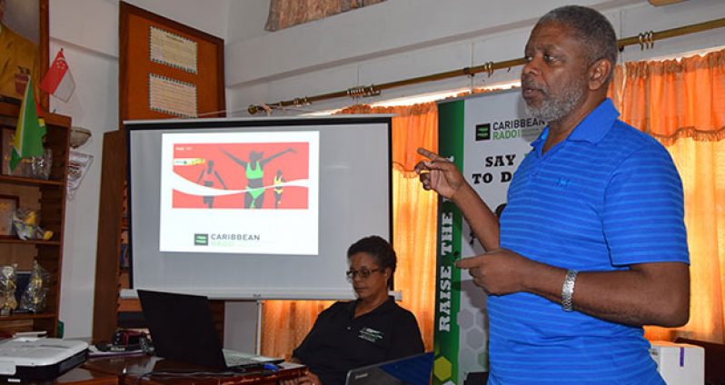 Doping Control Officer, Charles Corbin, during one of the presentations on Anti-Doping at yesterday's workshop. Sitting is Guyana's Caribbean RADO Board Member, Dr Karen Pilgrim.
