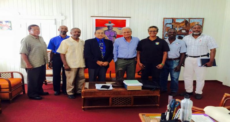 Education Minister Dr Rupert Roopnarine is flanked by GOA executives.