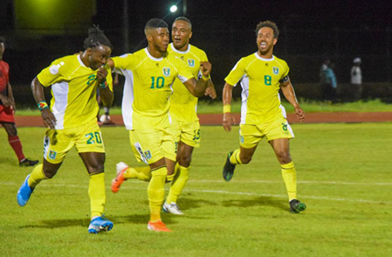 Trayon Bobb (first from left) celebrates with Emery Welshman, Neil Danns and captain Sam Cox after finding the net for Guyana in his side’s 5-1 win against Antigua and Barbuda at the National Track and Field Centre.