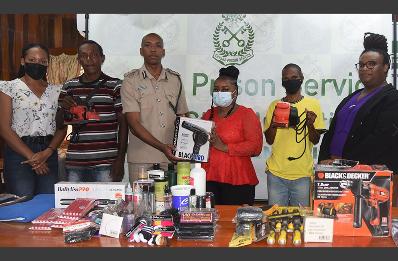 Director of Prisons, Nicklon Elliot, makes the presentation to Naomi Adams. Also in the picture are Technical Officer Rae-Dawn Corbin, Alvin Rudder, Shemroy King, and Mrs. Marielle Bristol-Grant (GPS photo).