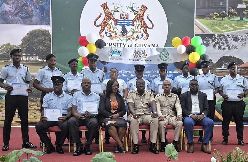 Director of Prisons Nicklon Elliot and Acting Deputy Director of Prisons, Kevin  Pilgrim, are flanked by some of the graduates and other officials at the graduation ceremony (GPS photo)