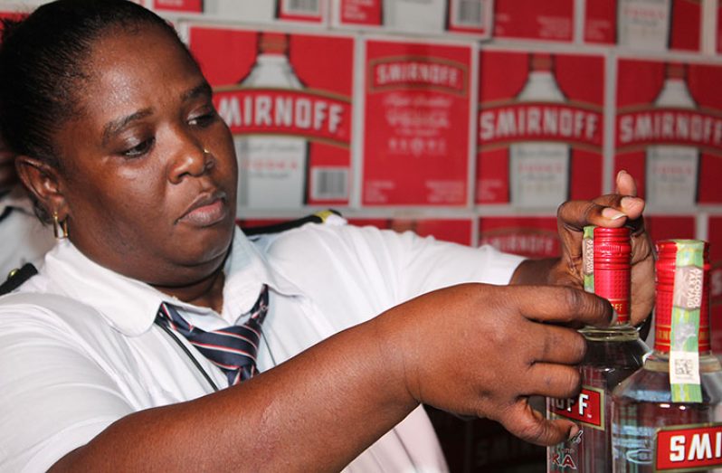 A GRA Customs officer placing the Excise Stamp on imported vodka during a recent outreach by the authority (GRA photo)