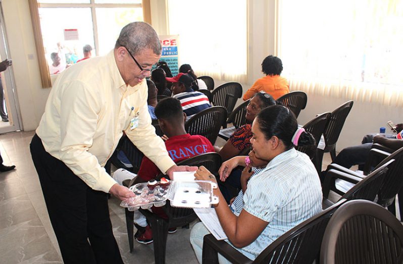 Commissioner-General of the GRA ,Godfrey Statia, sharing snacks to taxpayers in the waiting area of  GRA headquarters