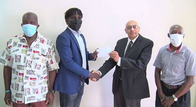 GRFU’s senior vice-president Joshua Griffith collects the cheque from GOA president K.A Juman-Yassin in the presence of manager George David (left) and secretary Terrence Grant.